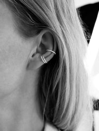 Tjej som bär tre ear cuff ringar i silver 